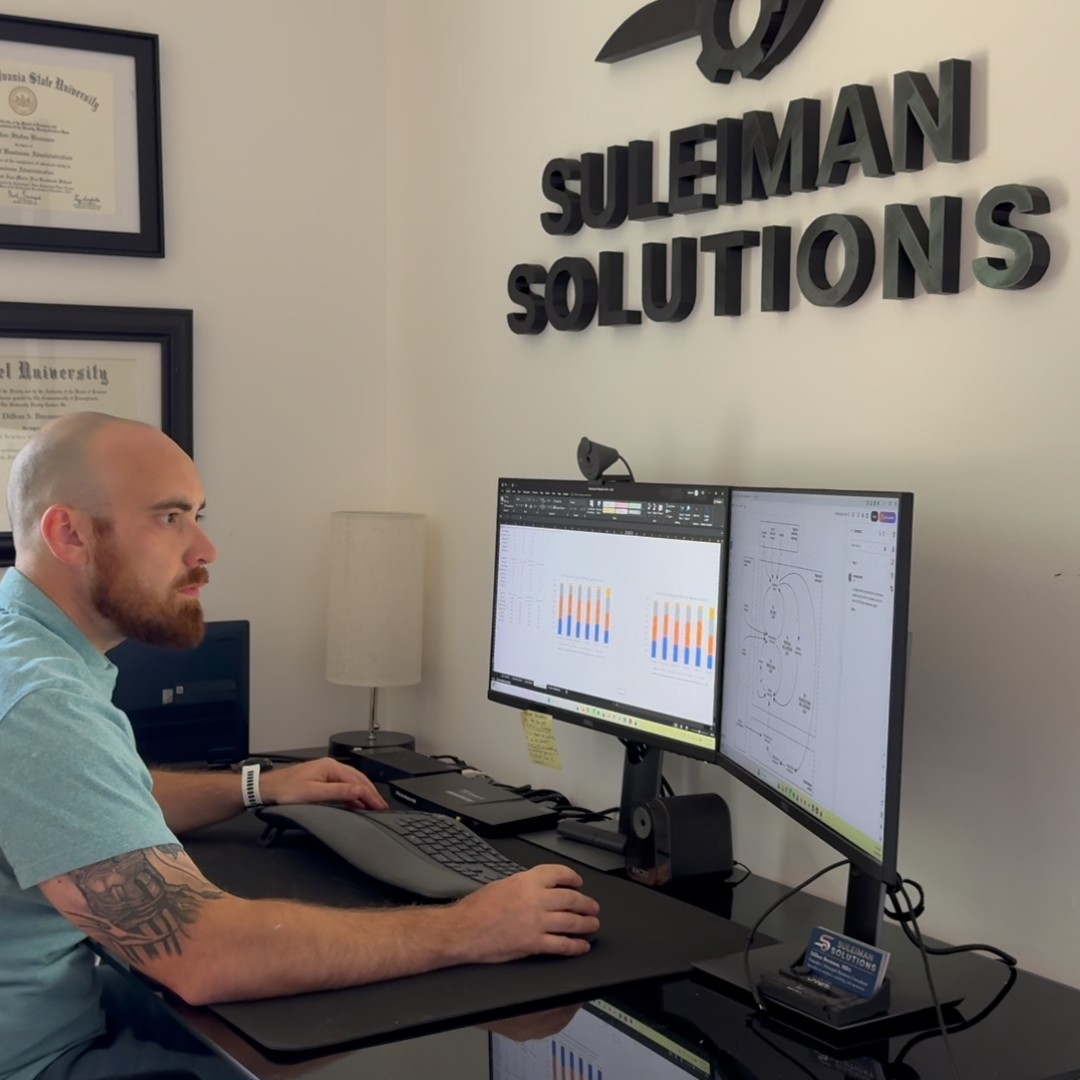 Dillon Brennan reviewing analytics dashboards at the Suleiman Solutions office