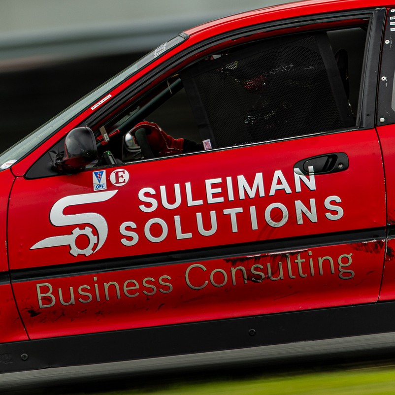 The Suleiman Solutions liveried race car on track